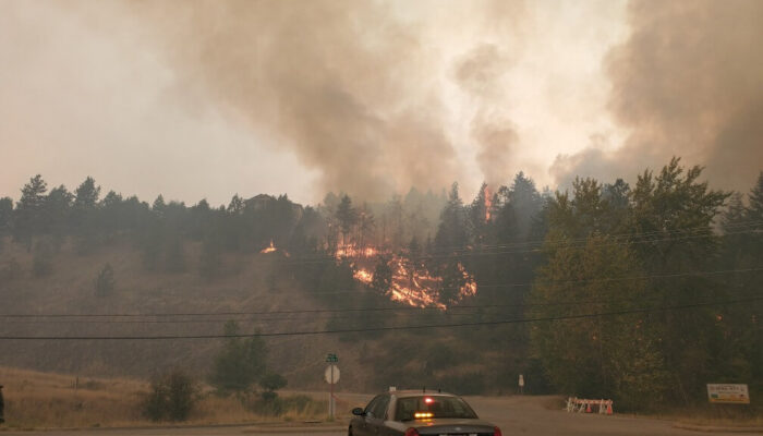 Une voiture de police banalisée de la GRC face à un incendie de forêt à West Kelowna, en Colombie-Britannique.